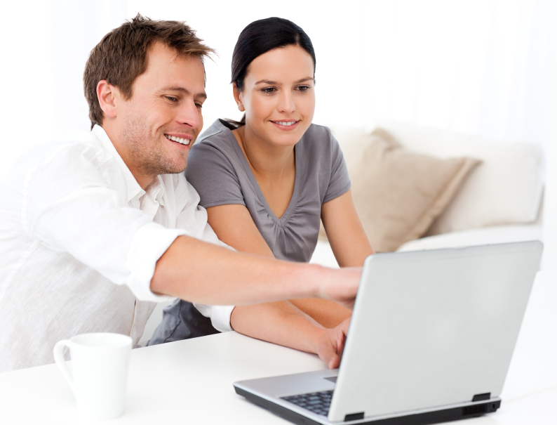 Cute man showing something on the laptop screen to his girlfriend in the living room